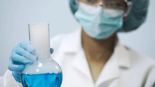 Demonstração de reação química, mulher segurando frasco com líquido evaporante — Fotografia de Stock