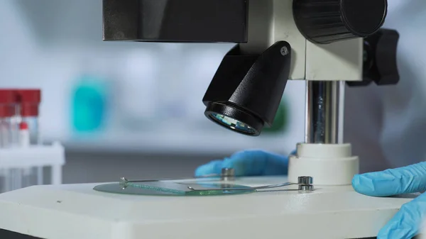 Close-up de equipamentos médicos, assistente de laboratório olhando para o microscópio, medicina — Fotografia de Stock