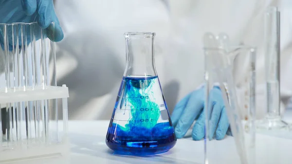 Close-up van de erlenmeyer met blauwe vloeistof, chemische experiment in laboratorium — Stockfoto