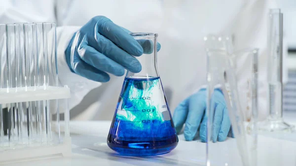 Vista de frasco cónico con líquido cambiando de color a azul, bioquímica —  Fotos de Stock