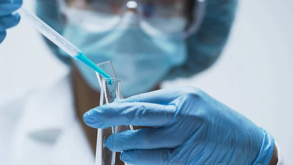 Química femenina añade gotas de sustancia azul en tubos de ensayo, investigación de laboratorio — Foto de Stock