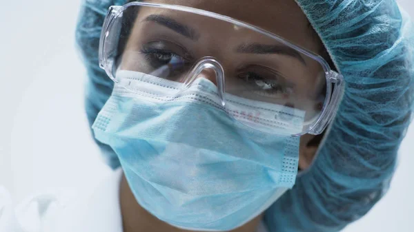 Крупный план красивой женщины-ученого лица с защитными очками, медициной — стоковое фото