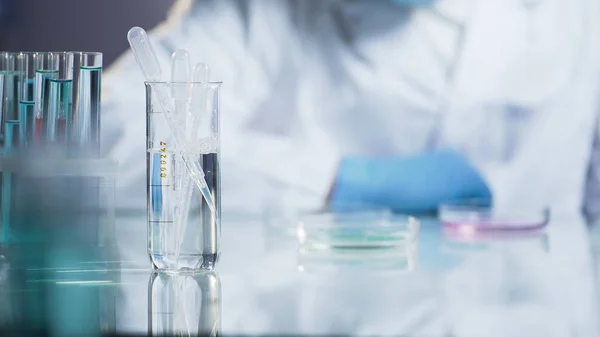 Técnico de laboratorio observando la reacción de la mezcla en vidrio, investigación científica — Foto de Stock