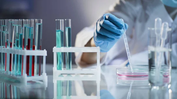 Kemist praktikant blandning vätskor, väntar på kemisk reaktion på science lab — Stockfoto