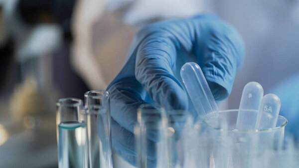 Лаборатория-ассистент проводит тесты в лаборатории, изучает жидкие вещества
