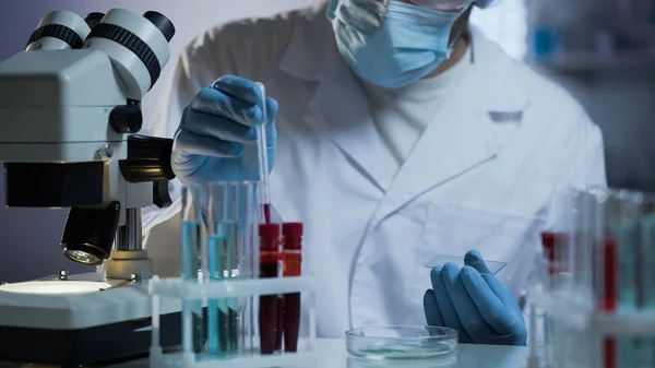 Trabalhador de laboratório médico preparando vidro para testes com base em amostras de sangue — Fotografia de Stock