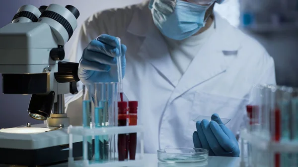 Worker of medical laboratory preparing glass for tests based on blood samples Stock Image