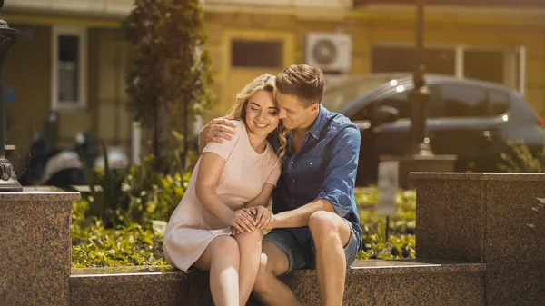 Cuplu tandru îmbrățișând pe bancă, zâmbind și bucurându-se de întâlnire romantică, dragoste — Fotografie, imagine de stoc
