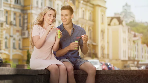 Pareja haciendo burbujas de jabón, relación romántica de los jóvenes citas — Foto de Stock