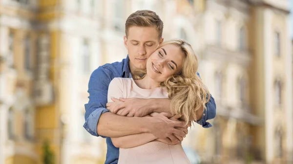 Man kramar hans flickvän bakifrån, Söt romantisk relation, ömhet — Stockfoto