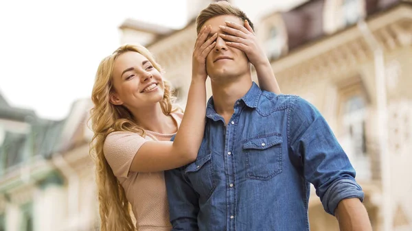 Flickvän kommer bakifrån och som täcker pojkvänner ögon, romantisk överraskning — Stockfoto