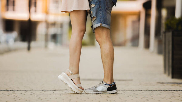 Feet of male and female close to each other, girl raising on tiptoes, dating