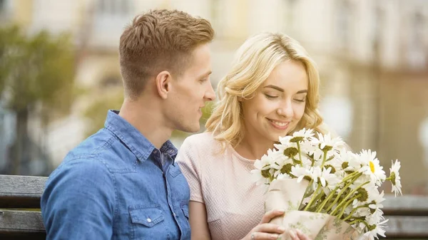 Ragazza felice profumando bei fiori, regalo dal fidanzato amato, appuntamento romantico — Foto Stock