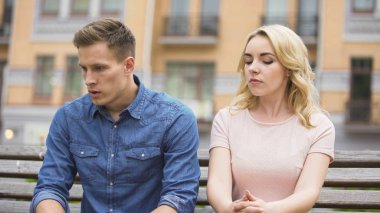 Üzgün çift oturma birbirlerine, kızgın adam kıskanç, ağlamak için kız yanındaki