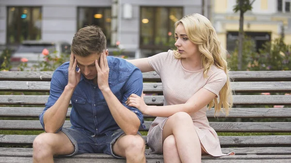 Orolig kille sitter på bänken, Flickvän lugnande honom, problem och stöd — Stockfoto