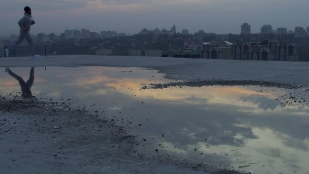 Mann macht Morgenlauf auf Dach seines Hauses, Ladung Lebendigkeit und Energie — Stockvideo