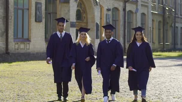 Graduados de la universidad saltando alto, feliz de recibir diplomas, educación — Vídeos de Stock