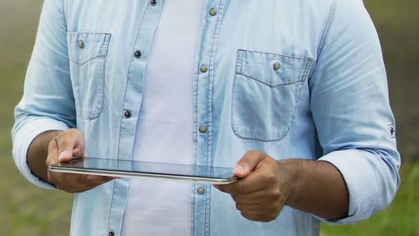 Freelancer masculino trabajando en tableta al aire libre, manos haciendo zoom de archivos en pantalla táctil — Vídeo de stock