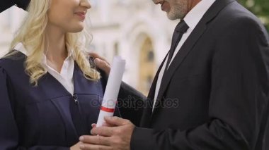 Babası mezuniyet töreninde, Aile destek öpüşme neşeli kız öğrenci