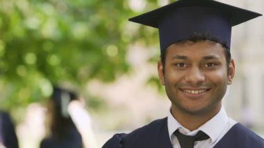 Mutlu bir şekilde gösterilen onun diploması, uluslararası eğitim sistemi biracial öğrenci