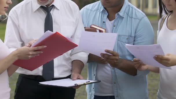 Professor i litteratur förklarar studenter grupp Detaljer för forskningsprojekt — Stockvideo