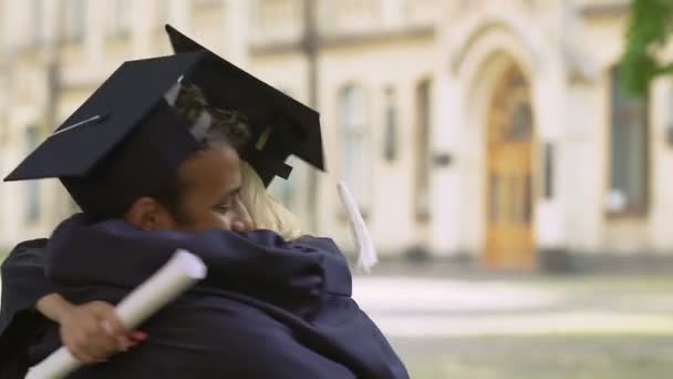 Estudantes de graduação multiétnicos se divertindo abraçando e parabenizando uns aos outros — Vídeo de Stock