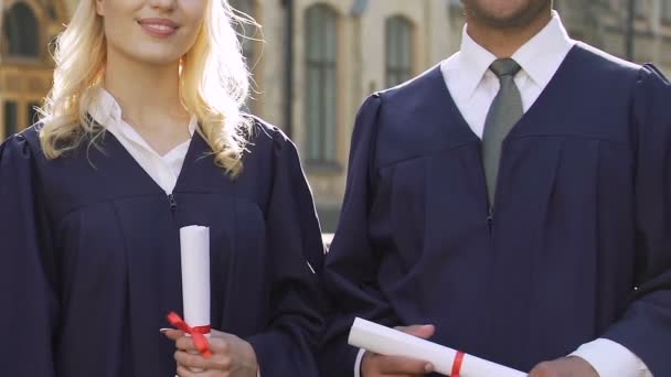 Casal alegre de estudantes multirraciais sinceramente sorrindo mostrando polegares para cima sinal — Vídeo de Stock