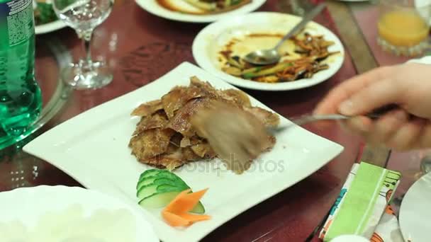 Ospite del banchetto che prende carne fritta grassa appetitosa dal piatto sul tavolo del ristorante — Video Stock