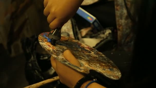 Художница держит мольберт и рисует картину на холсте масляными красками, искусством — стоковое видео