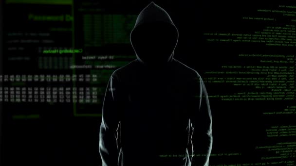 Sylwetka mężczyzna hacker w Bluza z kapturem stoi przed kod komputerowy animowane — Wideo stockowe