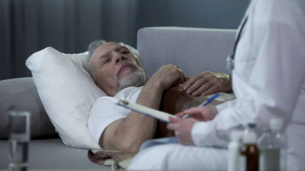 Homme adulte allongé sur le canapé et parlant avec le médecin des problèmes de santé, la maladie — Photo