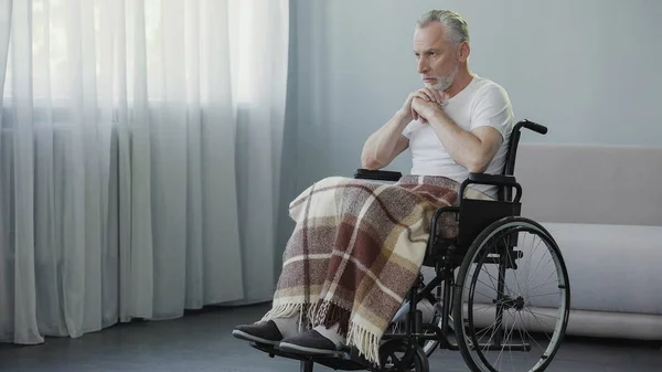 Régi beteg férfi ül tolószékben, és imádkoznak, depresszió és a szörnyű betegség — Stock Fotó