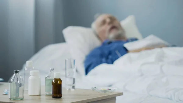 Terminally ill male sleeping in hospital after taking painkillers, medication