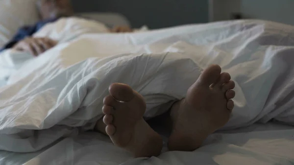 Homme à la retraite dormant au lit, odeur désagréable et gêne due à un champignon du pied — Photo