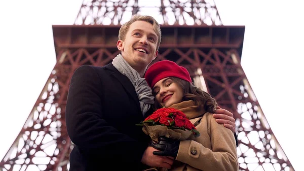 Man knuffelen geliefde vrouw op romantische date, Dame houdt van mooie bloemen — Stockfoto