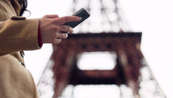 Дама ищет номер такси в приложении смартфона и звонит, чтобы забронировать автомобиль
