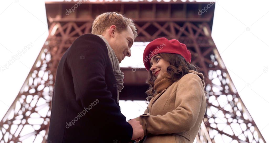 Handsome man looking at beautiful woman with love, first date, romance in Paris