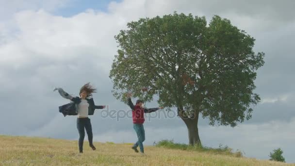 Allegro giovane uomo e donna che corre nel parco, coppia che si abbraccia, danza, salto — Video Stock