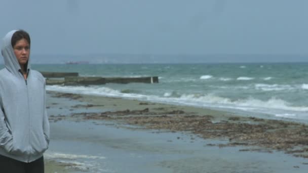 Mujer joven infeliz caminando por la playa. Mujer solitaria mirando el paisaje marino — Vídeos de Stock