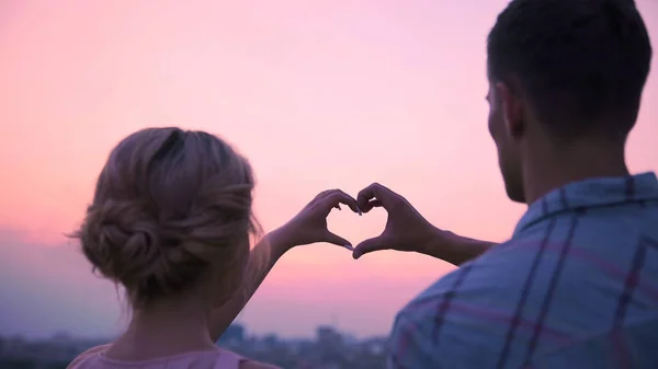 Amantes juntando as mãos em forma de coração, demonstrando seu amor — Fotografia de Stock