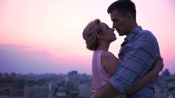 Handsome guy tenderly embracing his beautiful lady on open terrace, cityscape — Stock Photo, Image