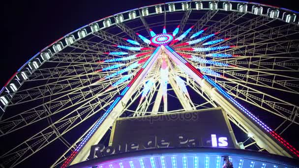 Roue d'observation colorée éclairée Rue de Paris tournant sous le ciel nocturne — Video