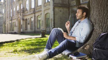 Çok uluslu adam yaratıcı fikri sketchbook içinde yazı Park ağacın altında oturan