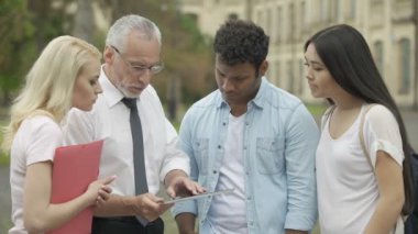 Kıdemli öğretmen gösteren yeni eğitim uygulaması tablet öğrencilere, Mbi çalışmalar
