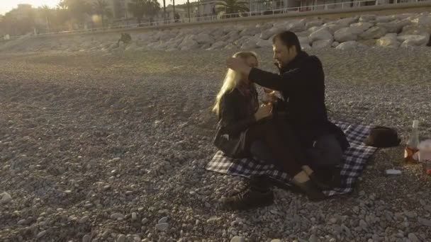 Male and female having picnic on beach in Nice, guy feeding girl with strawberry — Stock Video