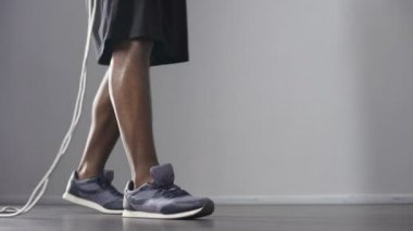 Erkek atlet bacaklar ile spor salonunda, ısınma-up ip atlama, atlama kardiyo egzersizi