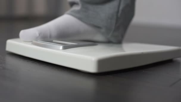 Homme obèse mesurant son poids à l'échelle de la santé, régime et perte de poids, gros plan 