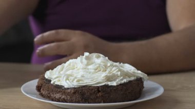 En iyi, krem ve vişneli şeker overeating kek üzerine ek koyarak adam şanti