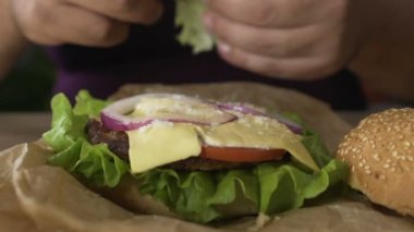 Boşanmış adam evde akşam yemeği için hamburger yiyin, yakın çekim hazırlanıyor