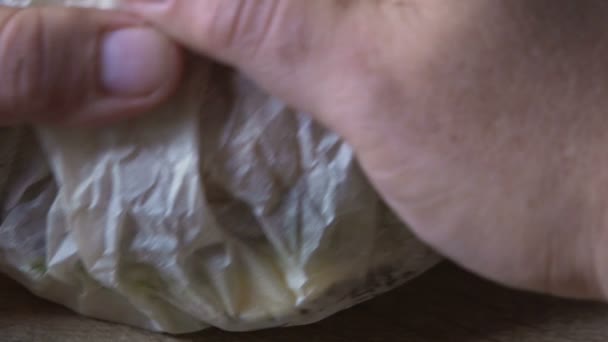 Homem solteiro desembrulhar e comer hambúrguer em casa, conceito de excesso de peso, close-up — Vídeo de Stock